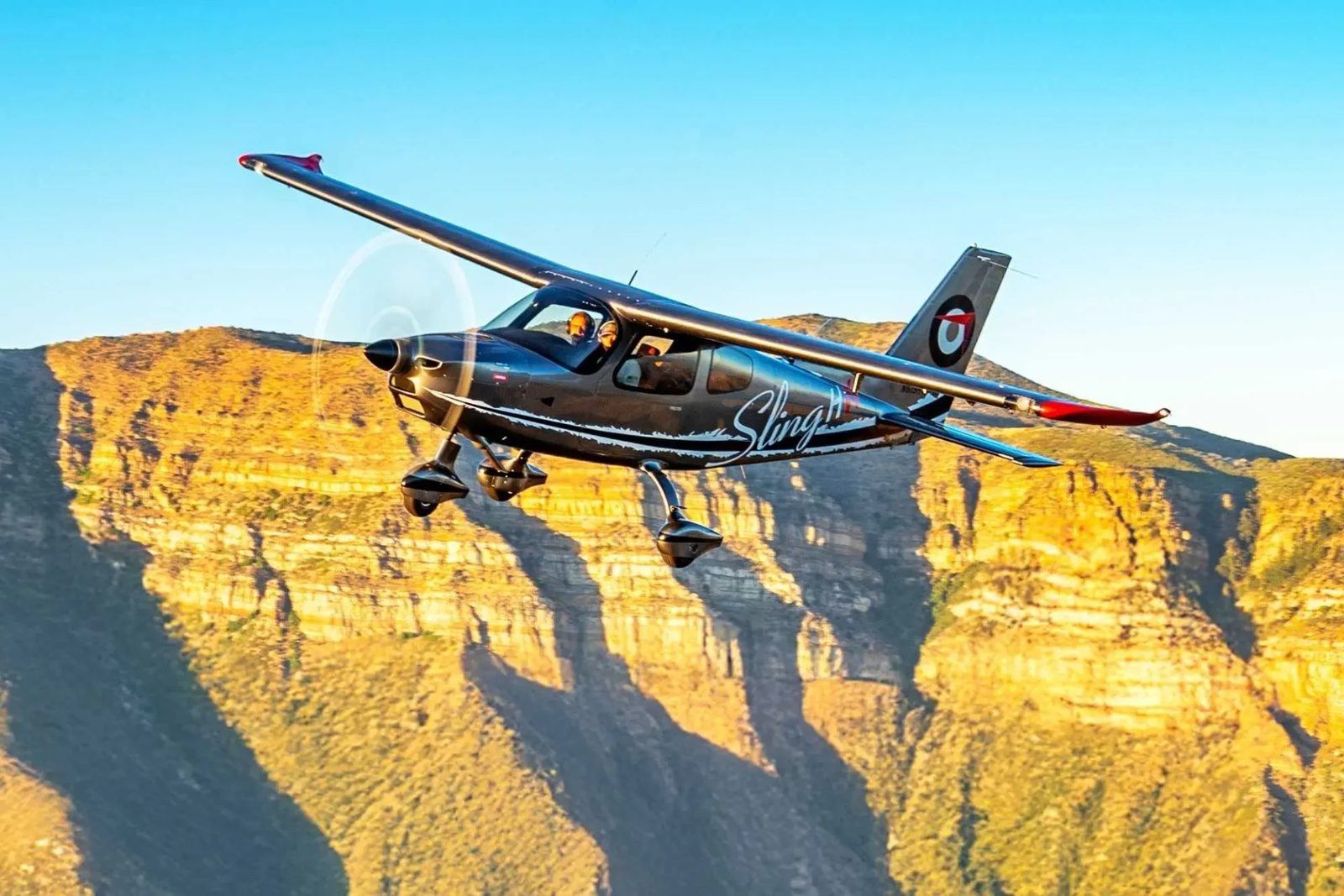 Sling High Wing in flight past sunlit cliffs (photo: Sling Aircraft)
